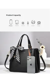 Capacity display of black leather tote with lychee pattern and checkered bow accessory