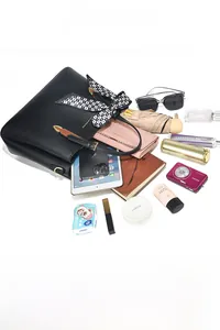 Spacious black leather tote bag showing large capacity with daily essentials inside
