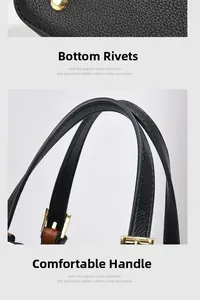Detail of black lychee leather handbag featuring gold bottom studs and adjustable handles
