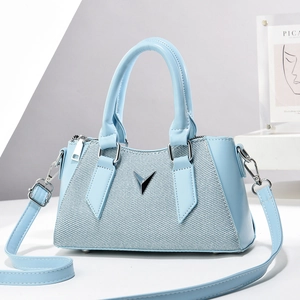 Blue woven patchwork pillow bag with silver V-logo and adjustable shoulder strap