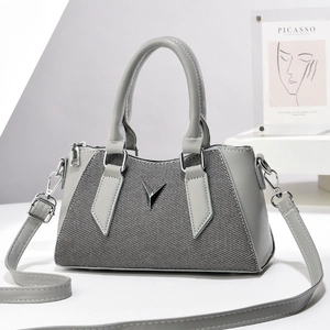 Chic gray pillow bag featuring minimalist patchwork and a silver V logo with shoulder strap