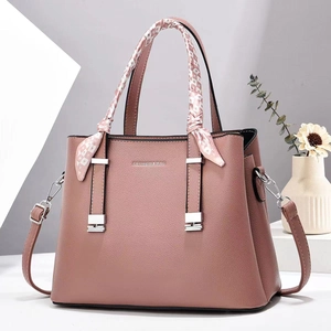 Elegant dusty pink pebbled leather crossbody bag with decorative silk scarf on handle