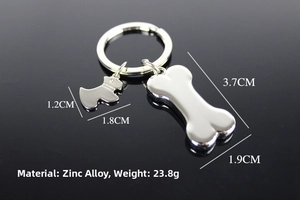 Macro view of bone and dog silhouette charms on a shiny silver metal keychain