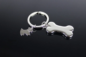 Macro shot of silver metal dog and bone shaped keychain pendants on a dark background