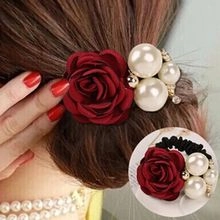 Dettaglio dell'elastico per capelli con rosa di velluto bordeaux e perle bianche