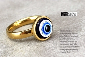 Macro detail of gold evil eye titanium steel ring showing anti-tarnish and durable texture