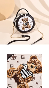 Détail du sac rond avec écusson ours en strass et texture de cuir grainé de haute qualité