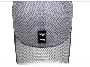 Close-up of gray breathable honeycomb mesh fabric and black logo on outdoor sun hat