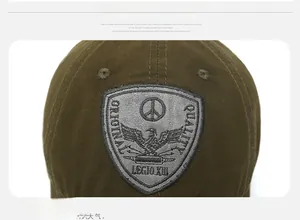 Close-up of olive green canvas baseball cap featuring a vintage shield embroidery patch