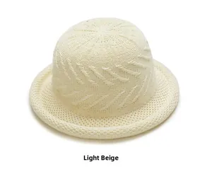 Detail showing the light beige woven dome hat with textured knit patterns and roll edge