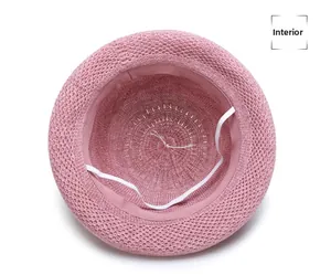 Detailed interior of a pink woven sun hat featuring a white elastic chin strap