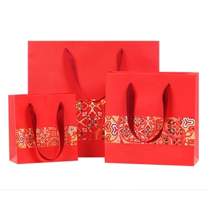 Red traditional gift bags with festive patterns in three sizes with carry handles