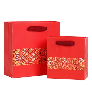 Ethnic red paper gift bags with Japanese patterns and rope handles on white background