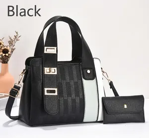 Detail view of black textured leather shoulder bag set with gold hardware accents