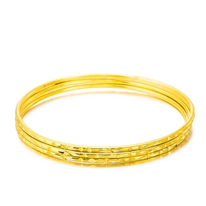 Three-piece set of golden textured bangles with intricate diamond-cut patterns