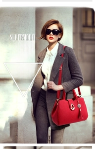 Chic red litchi texture handbag styled on model with a gold teardrop clasp and tassel