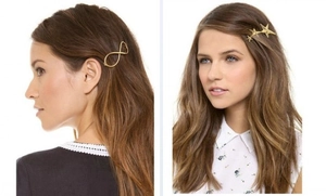 Detail showing gold infinity symbol and triple star geometric metal hair clips on model