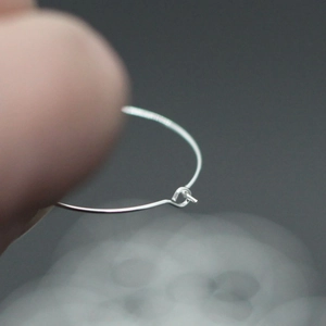 Macro shot of silver metal wire ring connector showing precise twist craft detail