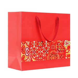 Ethnic red paper gift bag with festive gold floral patterns and matching ribbon handles