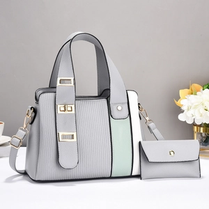 Detail of grey faux leather handbag with green stripes and matching mini purse pouch