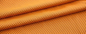 Macro view of high-density breathable orange cooling towel mesh fabric texture