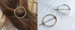 Minimalist metal circular hair clips in gold and silver finish shown on a model