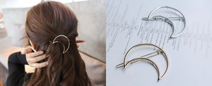 Detail of moon-shaped hair clips in gold and silver finish with model wearing view