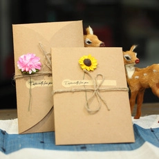 Detail of kraft paper gift boxes with dried flowers and twine for scratch art display