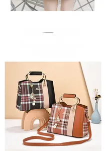 Detail of elegant plaid fabric and leather stitching on mini crossbody mobile phone bag