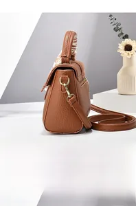 Side view of brown lychee texture crossbody bag with silk scarf wrapped on top handle