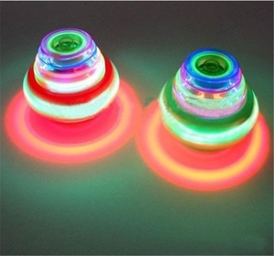 Close-up of two rotating LED musical spinning tops with colorful glowing light rings
