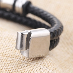 Macro shot of double-layer black braided leather bracelet with silver metal buckle