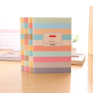 Carnets à rayures arc-en-ciel sur bureau en bois avec dos colorés et couvertures vives
