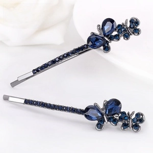 Detailed macro view of dark blue butterfly hair pins with sparkling crystals and gems
