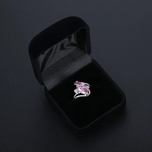 Close-up of a marquise cut pink gemstone ring in a premium black velvet jewelry box