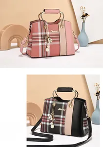 Detail view of plaid texture stitching and metal tassel charm on elegant shoulder bags