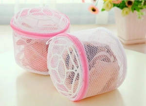 Close-up of cylindrical fine mesh laundry bag for bras with pink zipper and protective net
