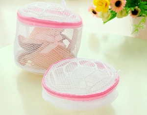Close-up of white mesh laundry bags with pink zippers in cylindrical and flat shapes