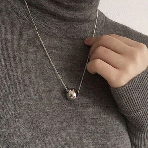 Minimalist S925 sterling silver 12mm ball pendant necklace on a dark knit sweater