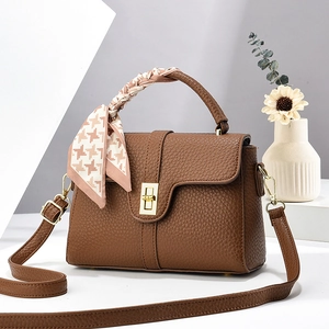 Brown lychee leather handbag with golden lock and houndstooth scarf on top handle
