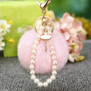 Porte-clés pompon rose avec chaîne dorée, perles blanches et pendentif de ballerine