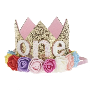 Close-up of glitter gold baby birthday crown with colorful felt roses and one lettering