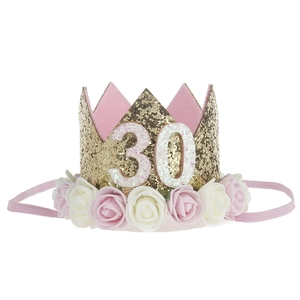 Detail of gold glitter birthday crown with number 30 and pink white fabric roses
