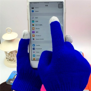 Close-up of blue knit touchscreen gloves operating a smartphone with gray fingertips