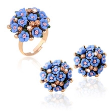 Detail of rose gold flower jewelry set with blue petals and sparkling crystal accents