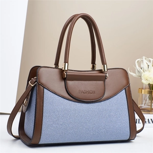 Modern patchwork pillow bag in blue woven fabric and brown leather with gold metal accents