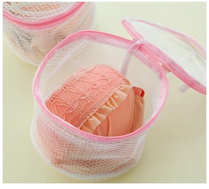 Macro shot of cylindrical fine mesh laundry bag protecting pink lace lingerie inside