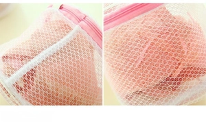 Close-up of fine mesh laundry bag with pink zipper and durable polyester weave texture