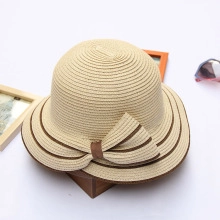 Detailed view of beige organza sun hat with striped bow on elegant wooden stand