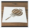 Close-up of a white coffee stencil featuring a cut-out lantern pattern on a wood surface